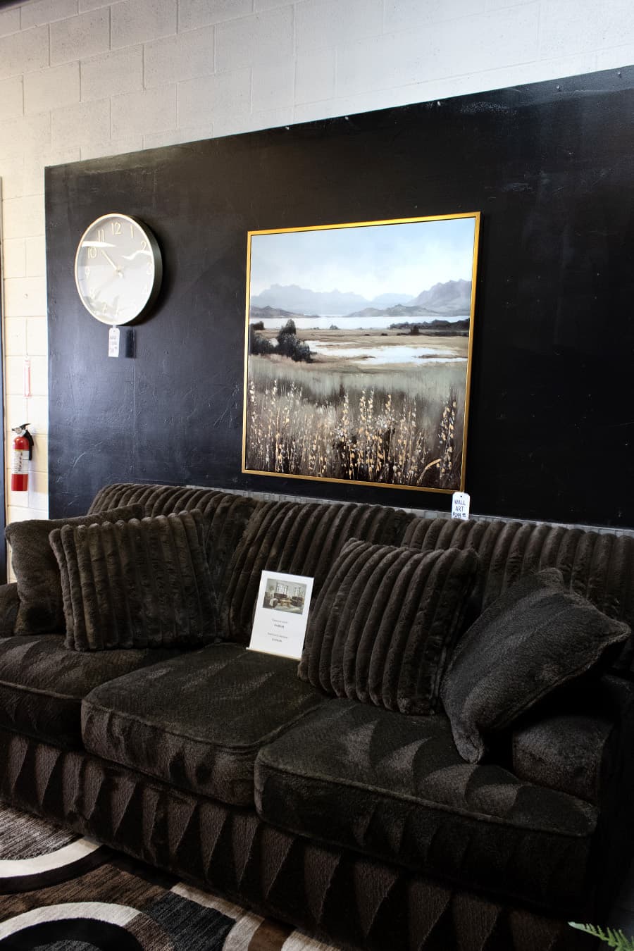 Sofa, wall art, and accent decor in a JK showroom setup